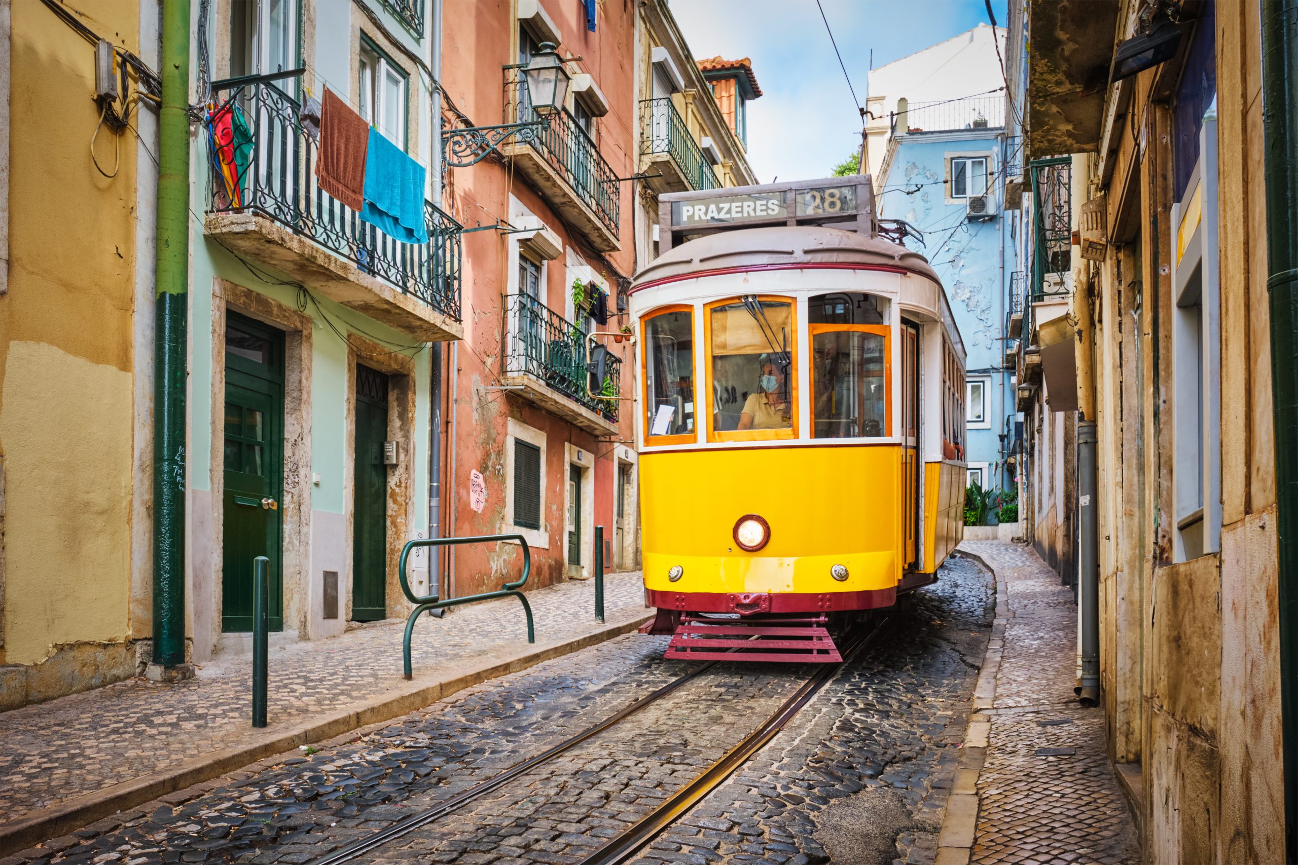 Tramway jaune dans une ruelle en pente du quartier de l'Alfama à Lisbonne